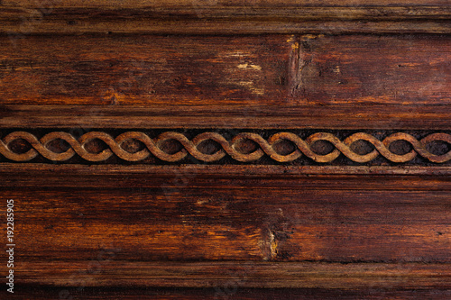 Vintage background. Elements of an old carved wooden door decorated with voluminous carved wooden elements imitating the weaving. A vintage concept of old antiques. Varnished old mahogany photo