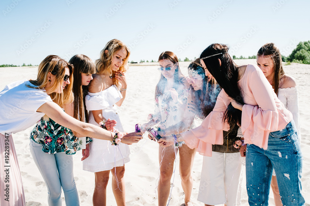 Beautiful happy stylish sexy young girls stand beach and light up colored  smoke bombs. Show Sincere smiles. Party in Style boho. Maiden evening Hen- parties. Bachelorette. Close up Portrait Stock Photo | Adobe