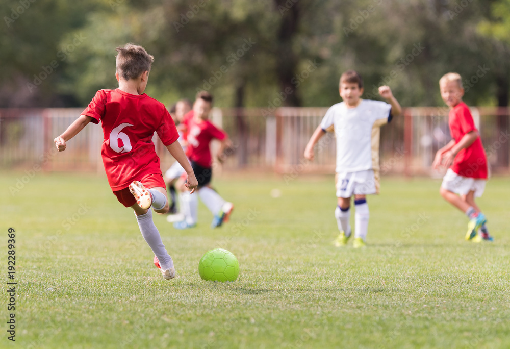 Naklejka premium Young children players football match on soccer field