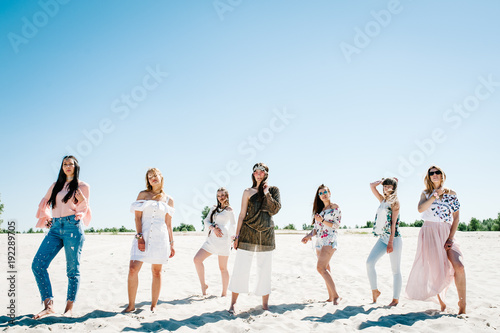 Beautiful stylish happy sexy slim young girls standding sand beach. Hands decorated buttonhole, Butonierka with ribbons flowers. Party in Style boho. Maiden evening Hen-parties. Bachelorette. Close up