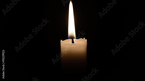 una candela su un fondo nero viene accesa e spenta con un soffio