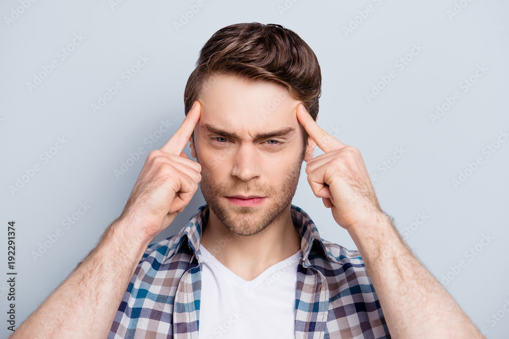 Close up portrait of attractive, concentrated guy thinking about something, holding fingers on temple, trying to find a solution, ideas, having bad memory, headache, standing over grey background Close up portrait of attractive, concentrated guy thinking about something, holding fingers on temple, trying to find a solution, ideas, having bad memory, headache, standing over grey background