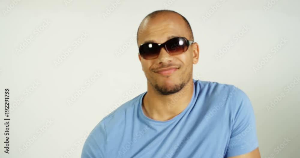 4K Funny confident mixed race man posing with sunglasses & showing off some moves, isolated on white in studio shot. Slow motion. 4K Funny confident mixed race man posing with sunglasses & showing off some moves, isolated on white in studio shot. Slow motion.