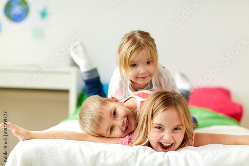 happy little kids having fun in bed at home photo