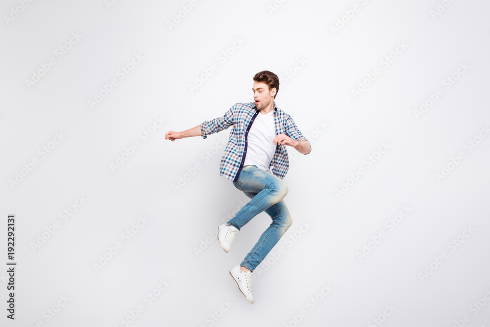 Mid-air shot of mad, crazy, cheerful, successful guy with bristle jumping, looking to the side, posing, gesturing against white background Mid-air shot of mad, crazy, cheerful, successful guy with bristle jumping, looking to the side, posing, gesturing against white background