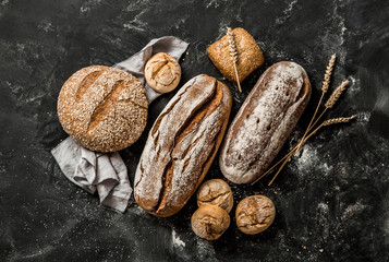 Papier peint photo Boulangerie Miches croustillantes rustiques sur fond noir  © pinkyone