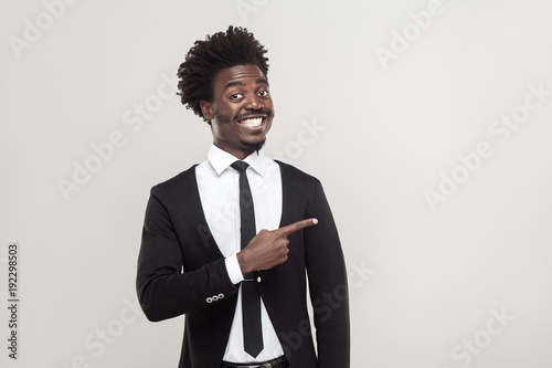 Businessman pointing finger at copy space and tothy smiling . photo