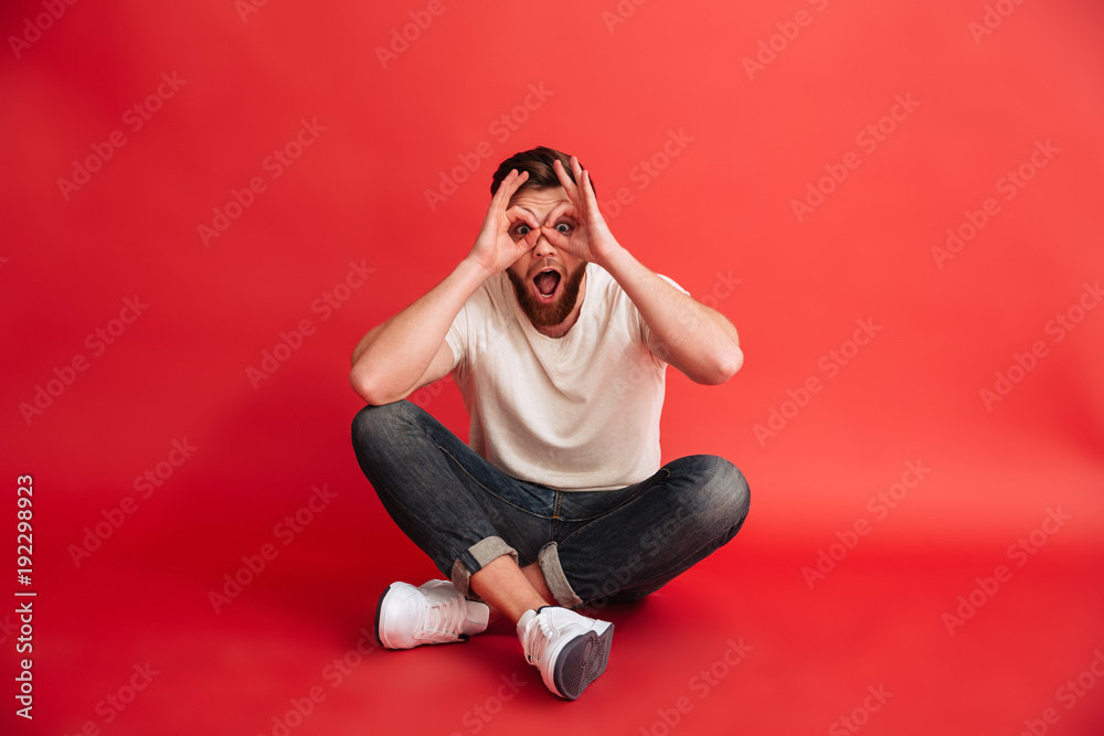 Emotional bearded man sitting on floor have fun. Emotional bearded man sitting on floor have fun.