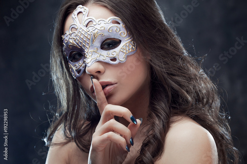 Mysterious and beautiful brunette with Venetian mask.