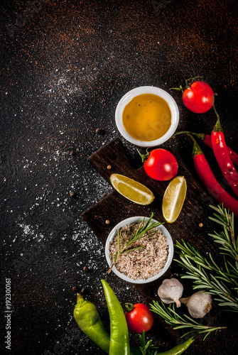 Food cooking ingredient, olive oil, herbs and spices, dark rusty background top view copy space