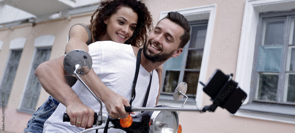 Happy couple on scooter making selfie on smartphone outdoor Happy couple on scooter making selfie on smartphone outdoor