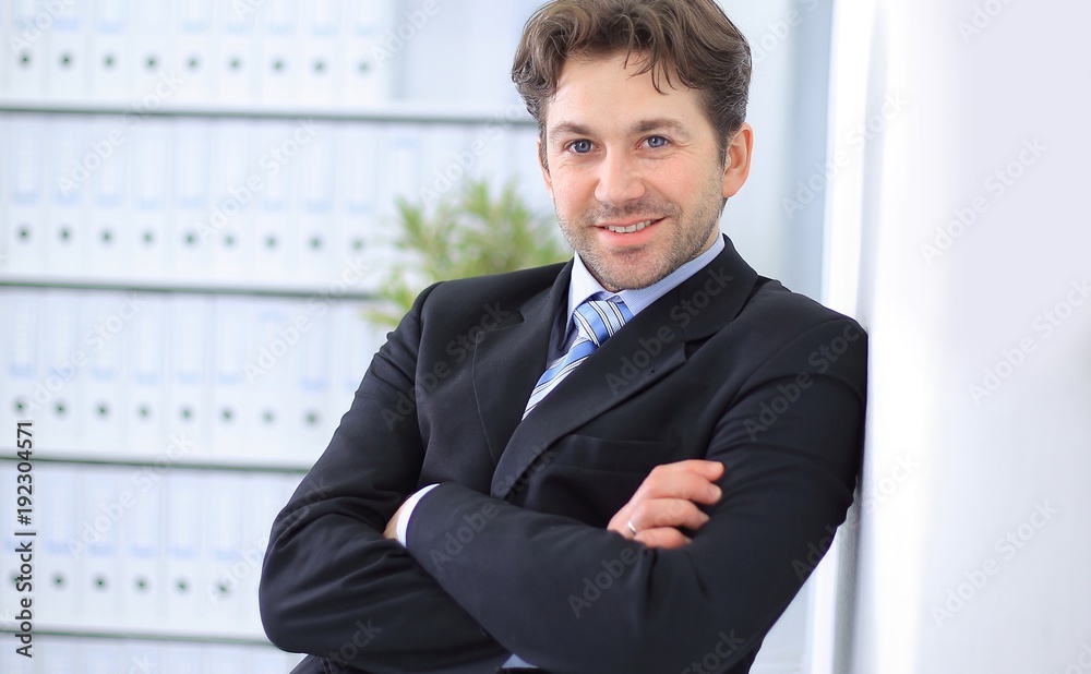 closeup.handsome businessman standing in the background of the office closeup.handsome businessman standing in the background of the office