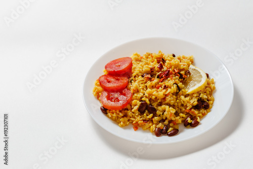bulgur pilaf with beans, barberry, paprika, garlic, tomato, lemon and spices on white background