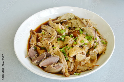 boiled duck in brown soup slice and topping chop spring onion on plate