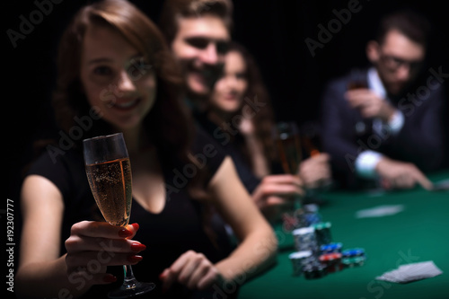 fashion woman with glasses of wine,sitting at a table in a casino