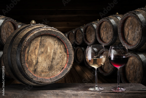 Wine barrel  and two wine glasses on the old wooden table.