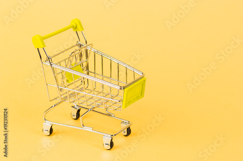 grocery cart on a yellow background, concept of buying business finance