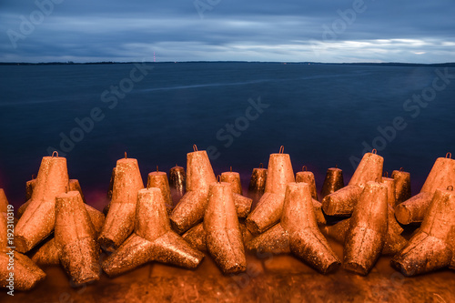 Fototapeta Naklejka Na Ścianę i Meble -  Breakwater near the Niegocin lake and rainy clouds at night in Gizycko, Masuria, Poland