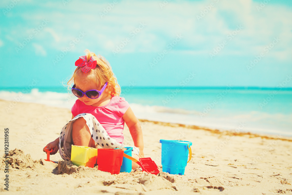 cute little girl playing with sand on beach cute little girl playing with sand on beach