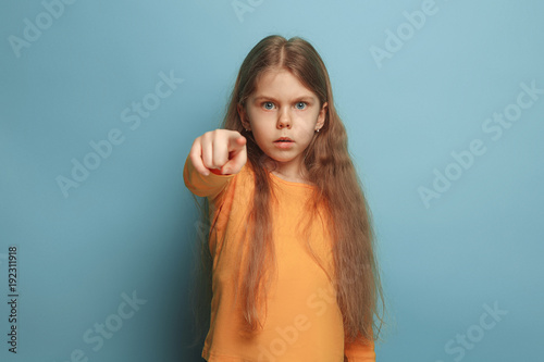 The determination. Teen girl on a blue background. Facial expressions and people emotions concept