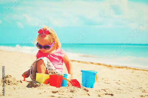 Fototapeta Naklejka Na Ścianę i Meble -  cute little girl playing with sand on beach