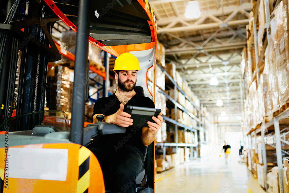 Obraz premium Warehouse worker doing logistics work with forklift loader