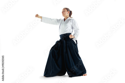 Aikido master practices defense posture. Healthy lifestyle and sports concept. Woman in white kimono on white background.