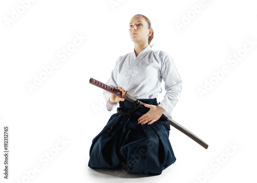 Aikido master practices defense posture. Healthy lifestyle and sports concept. Woman in white kimono on white background.