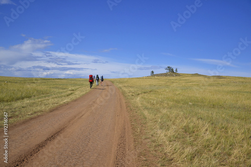 tourists are on the broad road, amid vistas, Lake Baikal, Olkhon Island, Khuzhir town