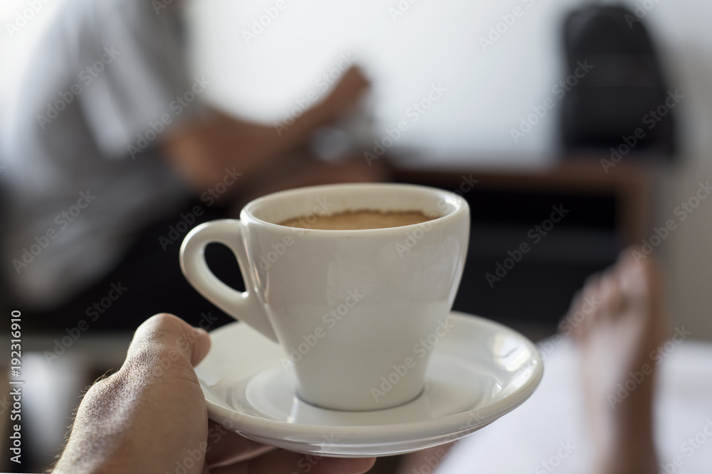 Fototapeta premium young man having a coffee on bed
