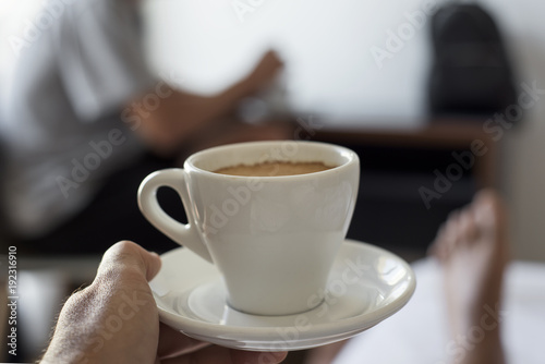young man having a coffee on bed