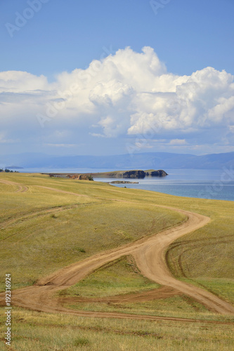 fork in the road of choice intertrack spaces unknown bright road on the background fields, clouds and water Lake Baikal Olkhon Khuzhir town
