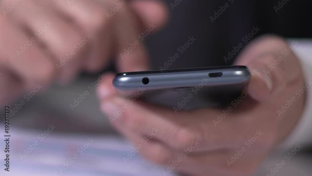 Financial expert scrolling on smartphone, reading business news, hands closeup Financial expert scrolling on smartphone, reading business news, hands closeup