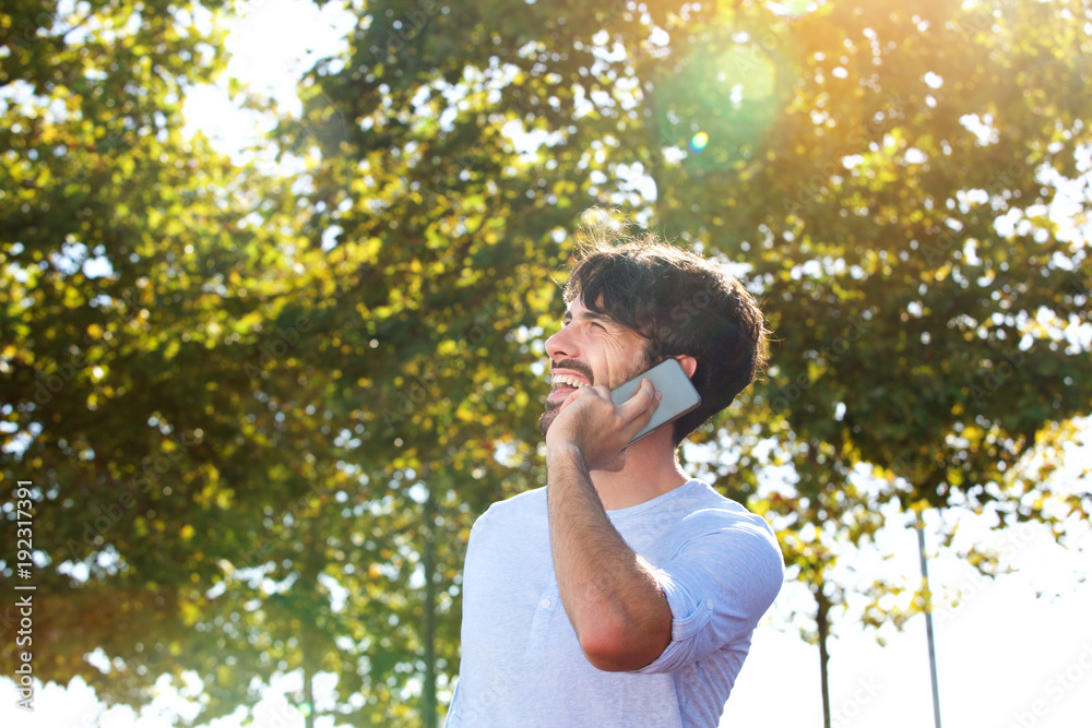 happy young man talking on mobile phone outdoors happy young man talking on mobile phone outdoors