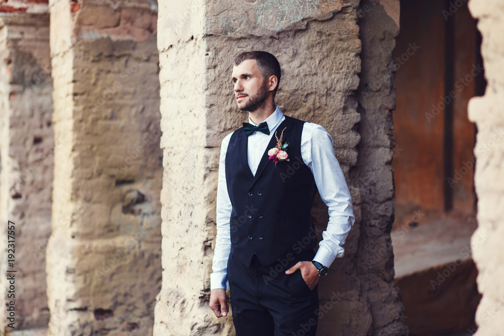 Sexy man groom in vest and bow tie posing Sexy man groom in vest and bow tie posing