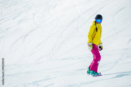 Image of athlete girl wearing helmet in sports clothes snowboarding