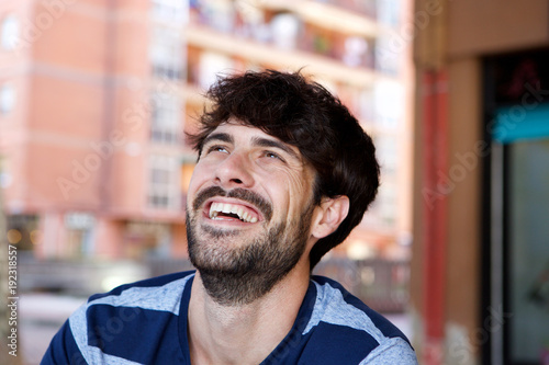 Close up handsome young man laughing outside