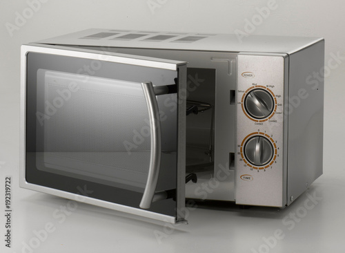 no brand microwave oven in silver. slightly open, on light-grey background