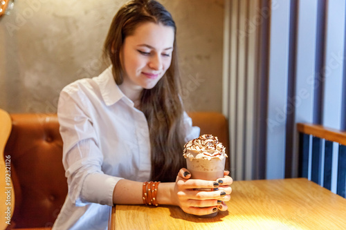 Young smiling hipster woman sitting playing guitar and write a song at cafe. Teen girl learning to play song and writing music. Hobby, lifestyle, relax, Instrument, leisure, education concept photo