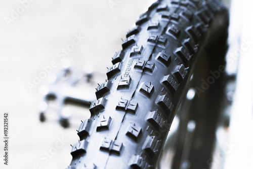 New and clean black mountain bike rear wheel detail and 29 x 2,2 tire close up, abstract with white background