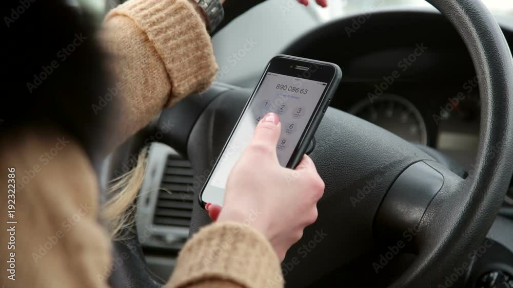 Close-up of woman's hands holding mobile phone in the car interior. Close-up of woman's hands holding mobile phone in the car interior.