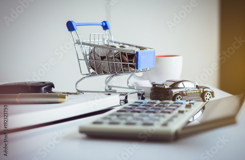 Saving money for cars with coins on mini shopping trolley cart,Car finance and loan concept