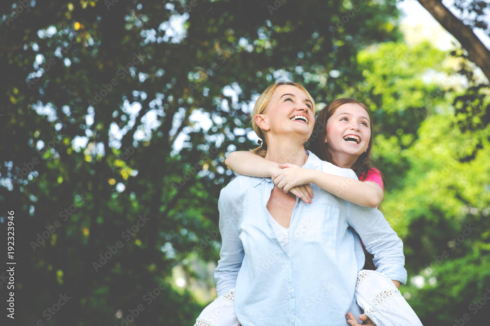 happy girl enjoying a piggyback ride on mothers back happy girl enjoying a piggyback ride on mothers back