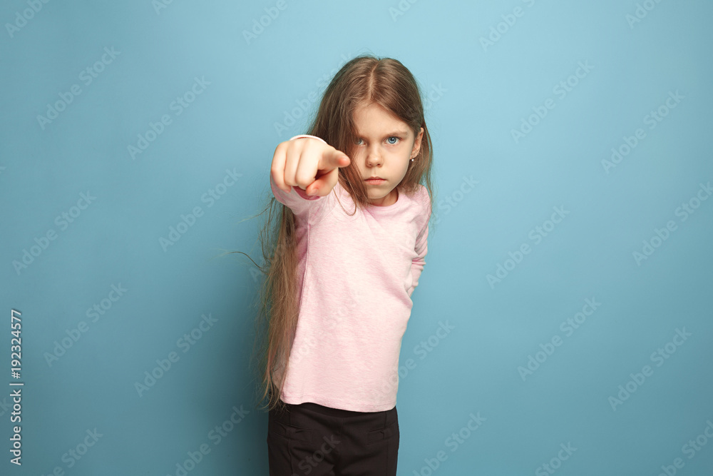 The determination. Teen girl on a blue background. Facial expressions and people emotions concept The determination. Teen girl on a blue background. Facial expressions and people emotions concept