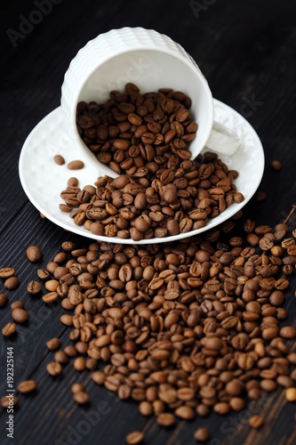 Roasted coffee beans in white mug on table 