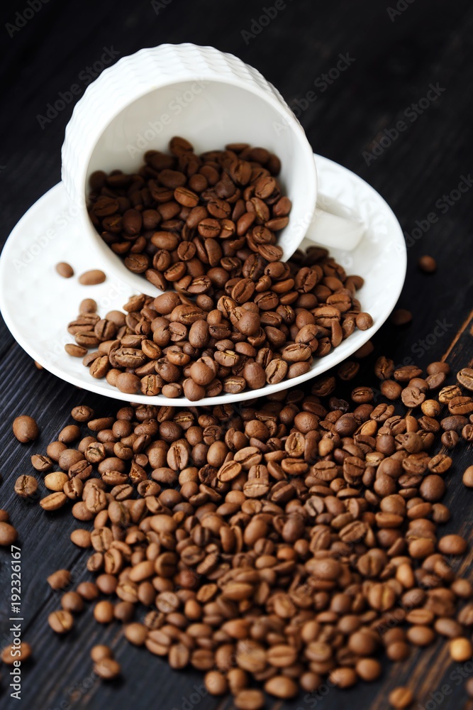 Roasted coffee beans in white mug on table  