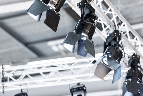 Lights attached to aluminium truss pointing down in a big exhibition hall