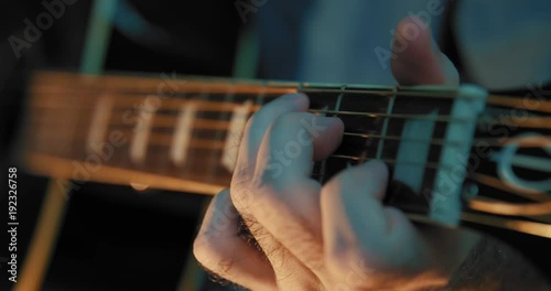 Close up of a musician playing the acoustic guitar at night. Shot on Blackmagic.
