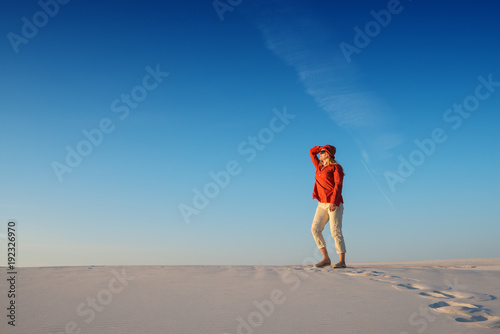Modern young woman admires magic landscape and dreams in desert