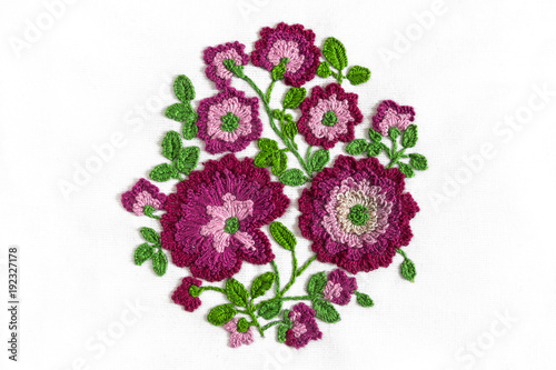 Embroidery bouquet of flowers in purple on white fabric with smooth handwork, trend 2018